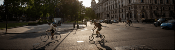 Image from CWIS2 Report. Two cyclists ride past Parliament Square, London.