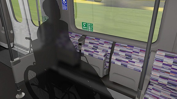 The inside of a moving train, the image focuses on an area designated for wheelchair users with a shadowy opaque silhouette of a person in a wheelchair.  
