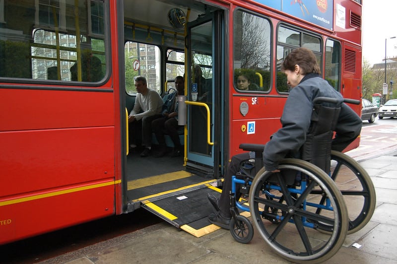 A wheelchair user trying to get up a Busses ramp to travel on the bus. 