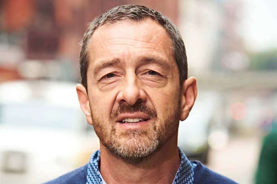 An image of Chris Boardman the new interim commissioner at Active Travel England, it shows his face and shoulders only, the background is blurry, and he has a blue shirt just visible one.