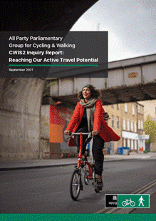 Front page of the APPG Cyclle and walking investment strategy report. It has an image of a woman of colour riding a Brompton style cycle under a bridge. 