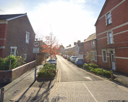 Google Streetview screenshot shows attractive road of Victorian terraced houses with many young street trees and borders of low shrubs on the carriageway between on-street parking bays.