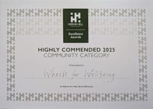 Copy of a Herne Hill Society Excellence Awards Certificate in the Community category, awarded to Wheels for Wellbeing. The text is black, with a cream background paper.